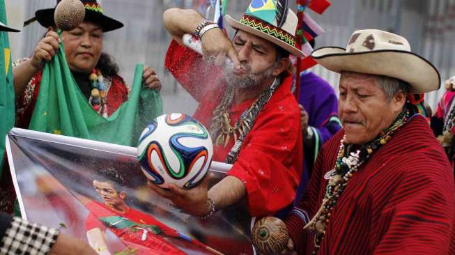 Dukun Peru melakukan ritual pada bola resmi Piala Dunia 2014 di Stadion Nasional, Lima, Selasa (10/6). [Reuters/Enrique Castro-Mendivil] 