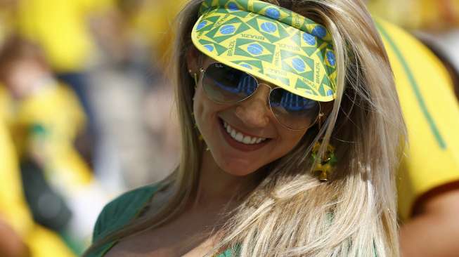 Seorang fans timnas Brasil menghadiri upacara pembukaan Piala Dunia 2014 di Stadion Corinthians, Sao Paulo, (12/6). (Reuters/Kai Pfaffenbach)