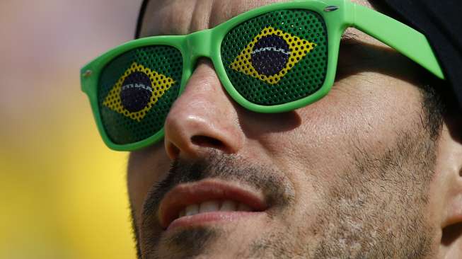 Seorang fans timnas Brasil menghadiri upacara pembukaan Piala Dunia 2014 di Stadion Corinthians, Sao Paulo, (12/6). (Reuters/Kai Pfaffenbach)