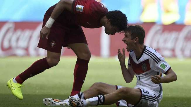 Pesepak bola Portugal  Pepe (kiri) dan Joao Pereira disela pertandingan di Fonte Nova arena, di Salvador, Minggu (16/6). [Reuters/Dylan Martinez] 