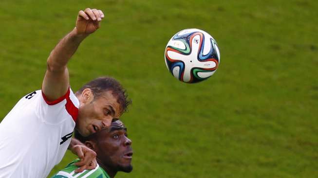 Pesepak bola Iran, Jalal Hosseini (kiri) berebut bola dengan pesepak bola Nigeria,Emmanuel Emenike di Baixada arena, di Curitiba, Minggu (16/6). [Reuters/Amr Abdallah Dalsh] 