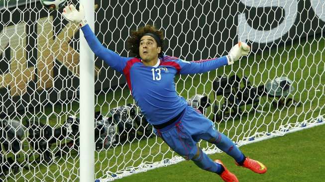 Penjaga gawang Meksiko, Guillermo Ochoa, terbang menyelamatkan gawangnya dari gempuran Brasil, Rabu (18/6/) [Reuters/Mike Blake].