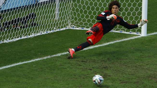 Kiper Meksiko, Guillermo Ochoa, gagal mengantisipasi tendangan penalti Klaas-Jan Huntelaar dalam laga Belanda kontra Meksiko di Fortaleza, Brasil, (29/6). (Reuters/Mike Blake)