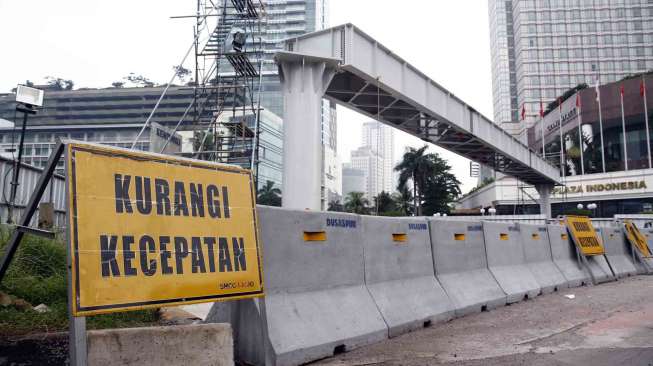Pemasangan konstruksi jembatan penyeberangan orang (JPO) sementara di depan Plaza Indonesia, Bundaran Hotel Indonesia sebagai pengganti JPO yang akan dibongkar di depan Hotel Pullman Jakarta, Kamis (3/7). [suara.com/Adrian Mahakam]