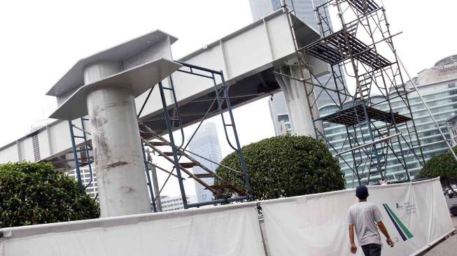 Pemasangan konstruksi jembatan penyeberangan orang (JPO) sementara di depan Plaza Indonesia, Bundaran Hotel Indonesia sebagai pengganti JPO yang akan dibongkar di depan Hotel Pullman Jakarta, Kamis (3/7). [suara.com/Adrian Mahakam]