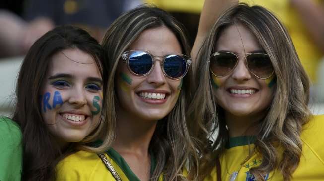 Tiga orang fans perempuan timnas Brasil di Stadion Castelao, Fortaleza, saat laga perempatfinal antara Brasil dan Kolombia, (5/7). (Reuters/Jorge Silva)