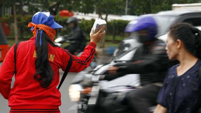 Pedagang pecahan uang kecil di depan Museum Bank Mandiri Jakarta, Selasa (8/7). [suara.com/Adrian Mahakam]