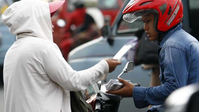 Pedagang pecahan uang kecil di depan Museum Bank Mandiri Jakarta, Selasa (8/7). [suara.com/Adrian Mahakam]