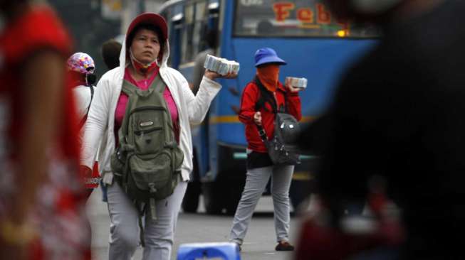 Pedagang pecahan uang kecil di depan Museum Bank Mandiri Jakarta, Selasa (8/7). [suara.com/Adrian Mahakam]