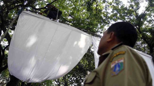 Persiapan tenda pilpres di TPS 17 & 18 di Taman Surapati untuk wilayah kelurahan Menteng, Jakarta, Selasa (8/7).  [suara.com/Adrian Mahakam]