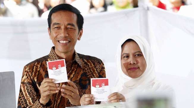 Calon Presiden nomor urut 2, Joko Widodo beserta Istri mencoblos di TPS 18 Kelurahan Menteng yang terletak di Taman Surapati Jakarta, Rabu (9/7). [suara.com/Adrian Mahakam]