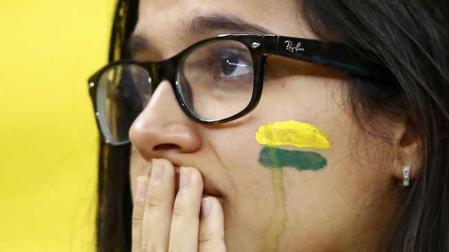 Seorang fans Brasil menangisi kekalahan tim favoritnya dari Belanda dalam laga perebutan juara tiga Piala Dunia di Brasilia, (13/7). (Reuters/Dominic Ebenbichler)