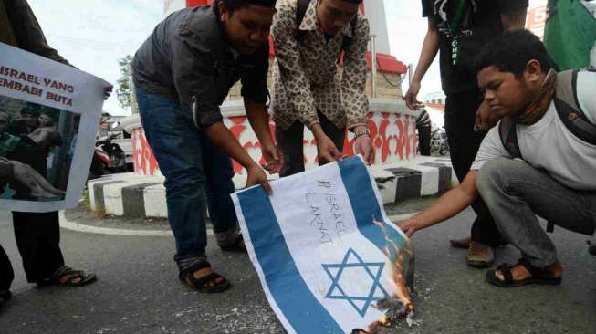 Aktivis Himpunan Mahasiswa Islam (HMI) membakar bendera Israel saat aksi menentang serangan Israel terhadap warga Palestina di Palu, Sulawesi Tengah, Sabtu (12/7).  [Antara/Basri Marzuki]