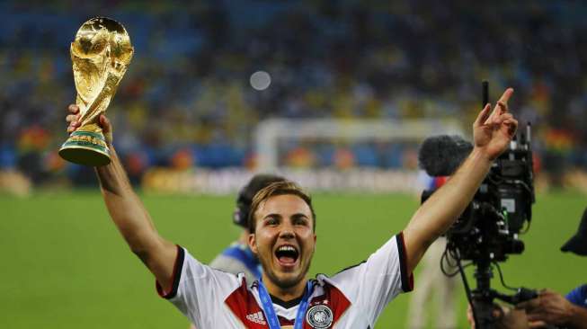 Mario Goetze mengangkat trofi Piala Dunia usai mengalahkan Argentina dalam Final Piala Dunia 2014 di stadion Maracana Stadium di Rio de Janeiro, Brazil, Minggu (13/7). [Reuters/Damir Sagolj] 