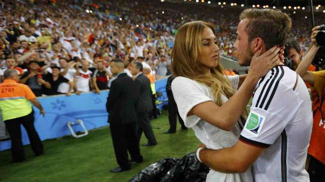 Mario Goetze bersama kekasihnya, Ann-Kathrin Broemmel usai mengalahkan Argentina dalam Final Piala Dunia 2014 di stadion Maracana Stadium di Rio de Janeiro, Brazil, Minggu (13/7). [Reuters/Darren Staples]  