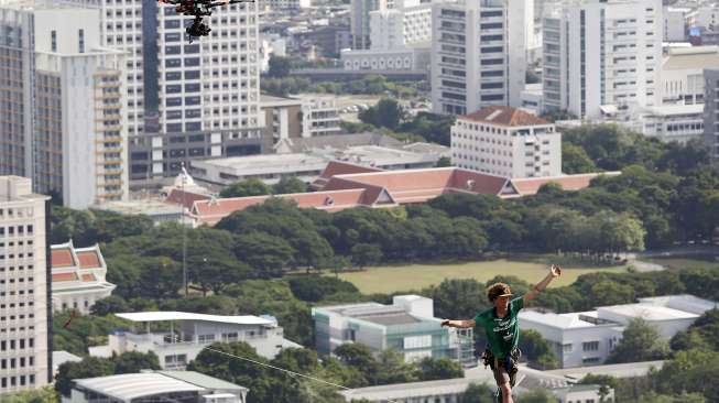 Andy Lewis, lelaki Amerika Serikat (AS) berhasil membuat rekor dunia slackline. Dia sukses berjalan di atas seutas tali pada ketinggian 169 meter, dalam tempo satu jam. Rekor itu dibukukannya di Bangkok, Thailand, Rabu (23/7/2014).  (REUTERS/Damir Sagolj)