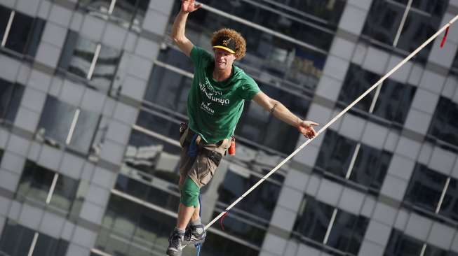 Andy Lewis, lelaki Amerika Serikat (AS) berhasil membuat rekor dunia slackline. Dia sukses berjalan di atas seutas tali pada ketinggian 169 meter, dalam tempo satu jam. Rekor itu dibukukannya di Bangkok, Thailand, Rabu (23/7/2014).  (REUTERS/Damir Sagolj)