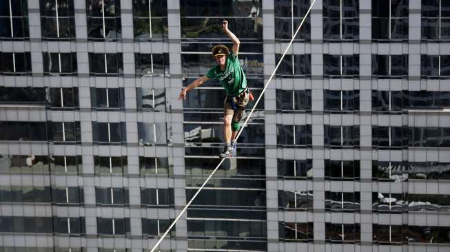 Andy Lewis, lelaki Amerika Serikat (AS) berhasil membuat rekor dunia slackline. Dia sukses berjalan di atas seutas tali pada ketinggian 169 meter, dalam tempo satu jam. Rekor itu dibukukannya di Bangkok, Thailand, Rabu (23/7/2014).  (REUTERS/Damir Sagolj)