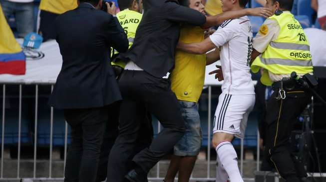 Fans Real Madrid (tengah, baju kuning) mencoba mendekati James Rodriguez di Santiago Bernabeu.(REUTERS/Juan Medina)  