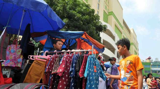 PKL kembali menggelar dagangannya di pinggir jalan Kebon Jati Tanah Abang di seberang Blok G, Jakarta, Kamis (31/7). [suara.com/Adrian Mahakam]