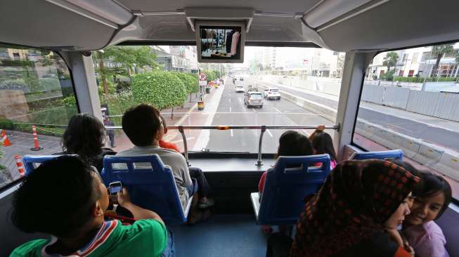 Warga memanfaatkan waktu liburan bersama keluarga untuk berwisata keliling Jakarta dengan bus City Tour, Kamis (31/7). [suara.com/Kurniawan Mas'ud]