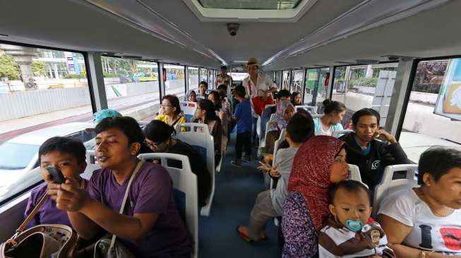 Warga memanfaatkan waktu liburan bersama keluarga untuk berwisata keliling Jakarta dengan bus City Tour, Kamis (31/7). [suara.com/Kurniawan Mas'ud]