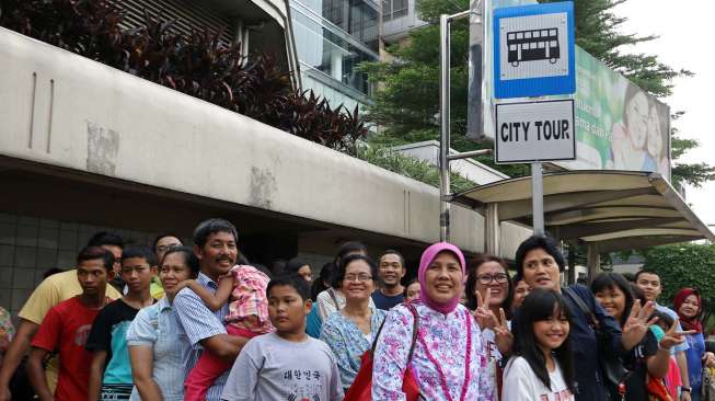 Warga memanfaatkan waktu liburan bersama keluarga untuk berwisata keliling Jakarta dengan bus City Tour, Kamis (31/7). [suara.com/Kurniawan Mas'ud]