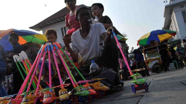 PKL kembali menyerbu Lapangan Museum Fatahillah untuk menjajakan dagangannya, Jakarta, Sabtu (2/8). [suara.com/Adrian Mahakam]