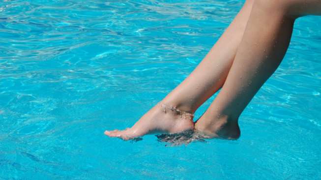 Ilustrasi kaki perempuan di kolam renang. (Shutterstock)