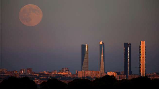 Pemandangan \"supermoon' di atas langit Kawasan Bisnis Empat Menara di Madrid, Spanyol, Minggu (10/8/2014). [Reuters/Sergio Perez]