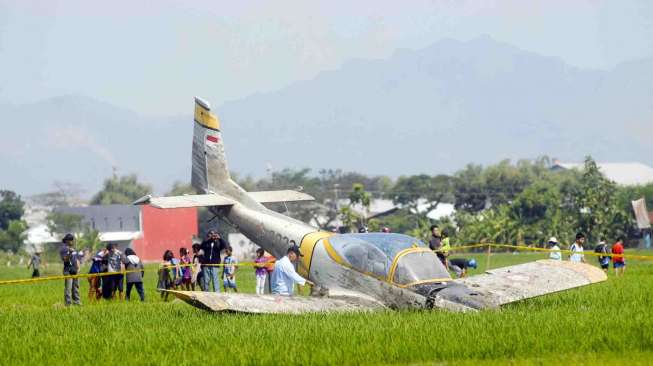 Personel TNI-AU mengamankan pesawat latih TNI-AU, Bravo AS-202 yang jatuh di areal persawahan Jogodayoh, Sukoharjo, Jateng, Selasa (12/8). [Antara/Andika Betha]