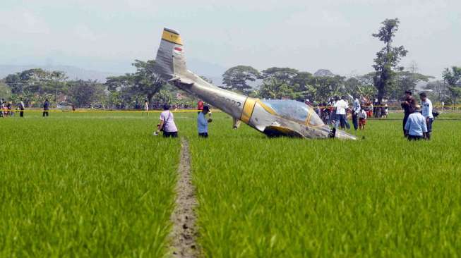 Personel TNI-AU mengamankan pesawat latih TNI-AU, Bravo AS-202 yang jatuh di areal persawahan Jogodayoh, Sukoharjo, Jateng, Selasa (12/8). [Antara/Andika Betha]