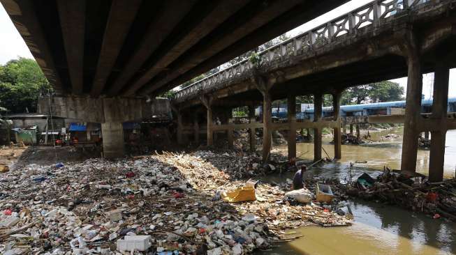 Seorang pemulung mengais rezeki di tumpukan sampah kali pintu air Karet Tanah Abang Jakarta, beberapa waktu lalu. [suara.com/Kurniawan Mas'ud]