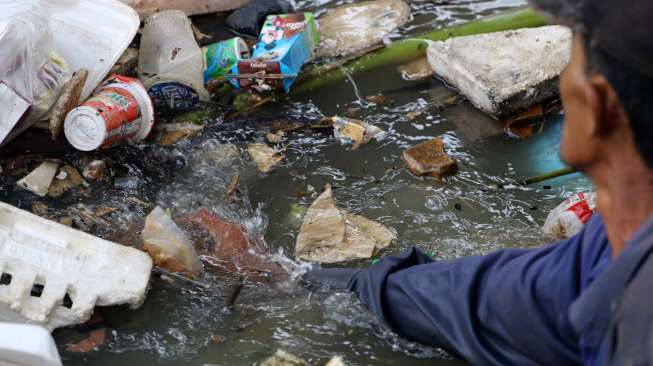 Seorang pemulung mengais rezeki di tumpukan sampah kali pintu air karet Tanah Abang Jakarta, beberapa waktu lalu. Suara.com/Kurniawan Mas'ud