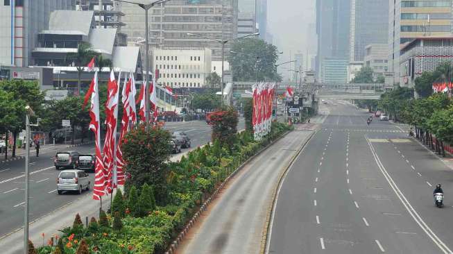 Jalan M.H Thamrin mengarah ke Jalan Medan Merdeka Barat maupun sebaliknya lengang, Jakarta, Kamis (21/8). [suara.com/Adrian Mahakam]