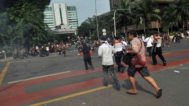 Bentrokan terjadi antara aparat dan massa pendukung Prabowo-Hatta di depan Bundaran Patung Kuda, Jakarta, Kamis (21/8). [suara.com/Adrian Mahakam]