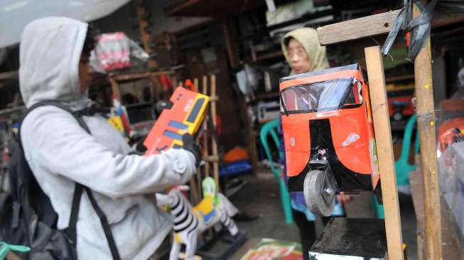 Penjual Mainan mobil-mobilan berbahan dasar kayu yang semakin ditinggalkan, di daerah Pasar Minggu, Jakarta, Jumat (22/8). [suara.com/Adrian Mahakam