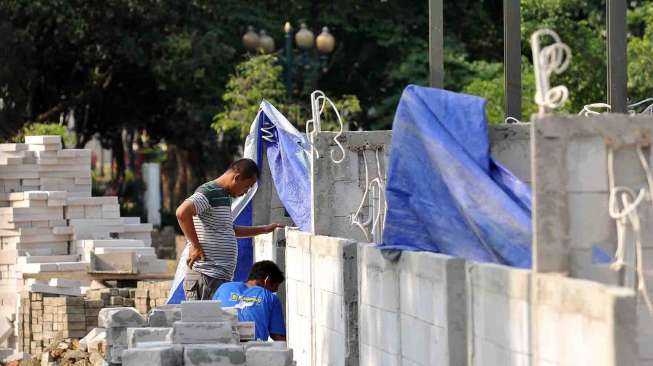 Pekerja menyelesaikan lokasi penampungan Pedagang Kaki Lima di Lapangan IRTI Monas, Jakarta, Sabtu (23/8). [suara.com/Adrian Mahakam]