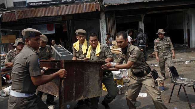 Aparat dari Polisi Pamong Paraja, Polri dan TNI melakukan pembongkaran terhadap sejumlah bangunan yang berada di pinggir kali Ciliwung, Jatinegara Jakarta, Kamis (28/8). [suara.com/Kurniawan Mas'ud]