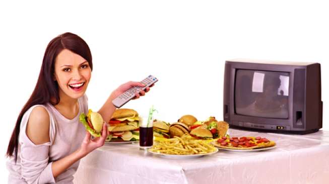 Ilustrasi perempuan menonton tv sambil makan. (Shutterstock)