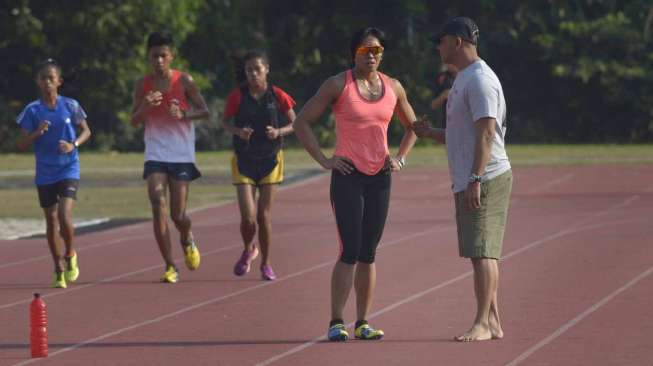 Altelt lari gawang putri pelatnas Asian Games 2014, Dedeh Erawati (kiri) berbincang dengan pelatihnya, Fahmi Fahrezzy (kanan) ketika berlatih fisik di Stadion Madya Senayan, Jakarta, Sabtu (13/9). [Antara/Saptono]