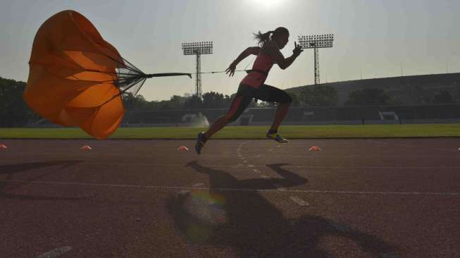 Altelt lari gawang putri pelatnas Asian Games 2014, Dedeh Erawati berlatih fisik menggunakan parasut di Stadion Madya Senayan, Jakarta, Sabtu (13/9). [Antara/Saptono]