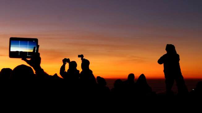 Sejumlah wisatawan mengabadikan momen matahari terbit di Taman Nasional Bromo Tengger Semeru (TNBTS) dari puncak Penanjakan I, Kecamatan Tosari, Kabupaten Pasuruan, Jawa Timur, Sabtu (12/9). [Antara/Suryanto]