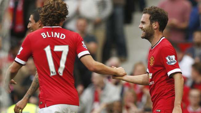 Daley Blind (kiri) memberikan selamat kepada Juan Mata usai menjebol gawang QPR [Reuters/Andrew Yates]