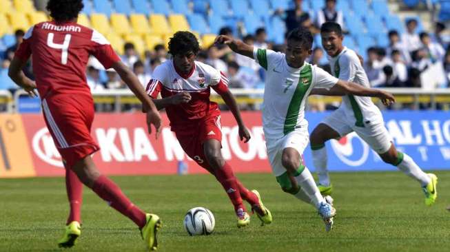 Pesepak bola Indonesia Ramdani Lestaluhu (tengah) berusaha menembus pertahanan pesepak bola Maladewa pada penyisihan grup E Asian Games 2014 di Incheon, Korsel, Kamis (18/9). [Antara/Saptono]