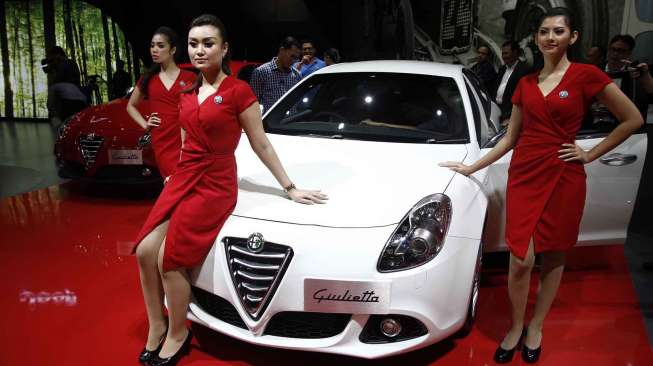 Wanita-wanita cantik berpose disamping mobil-mobil keren dan mewah yang dipamerkan di ajang Indonesia Internasional Motor Show (IIMS) 2014 di JIExpo Kemayoran, Jakarta, Jumat (19/9). [suara.com/Kurniawan Mas'ud]