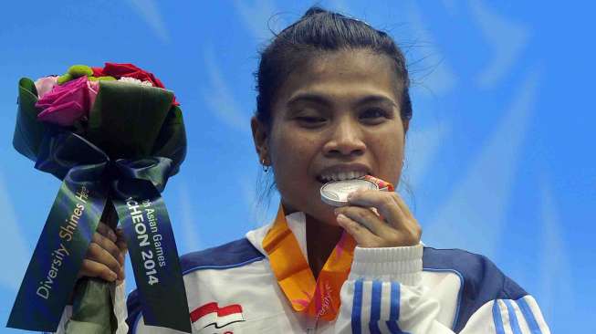 Atlet angkat besi putri Sri Wahyuni Agustiani memegang medali perak yang diraihnya pada angkat besi 48 kg Asian Games 2014 di Moonlight Garden Venue, Inchoen, Korsel, Sabtu (20/9). 