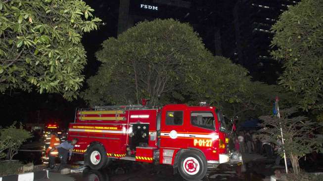 Petugas pemadam kebakaran berusaha memadamkan api yang membakar dua ruangan di lantai dasar gedung Kementerian Energi dan Sumber Daya Mineral (ESDM) di Jalan MH Thamrin, Jakarta, Jumat (19/9) malam.[Antara/Andika Wahyu]