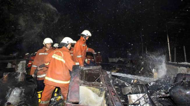 Petugas pemadam kebakaran berusaha memadamkan api yang membakar dua ruangan di lantai dasar gedung Kementerian Energi dan Sumber Daya Mineral (ESDM) di Jalan MH Thamrin, Jakarta, Jumat (19/9) malam. [Antara/Andika Wahyu]