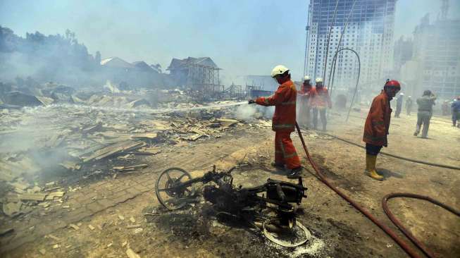 Petugas pemadam kebakaran memadamkan api yang membakar sejumlah rumah warga di kawasan Cipinang Besar Utara, Jatinegara, Jakarta Timur, Rabu (24/9). [Antara/Widodo S. Jusuf]